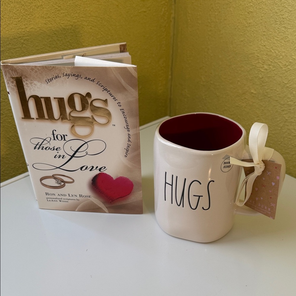 Rae Dunn Cup with book Kisses on one side and Hugs on other.